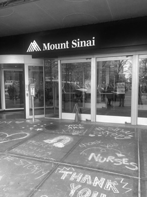 View of the front doors of Mount Sinai hospital with chalk drawings on the ground expressing "Thank You" and gratitude to the frontline workers