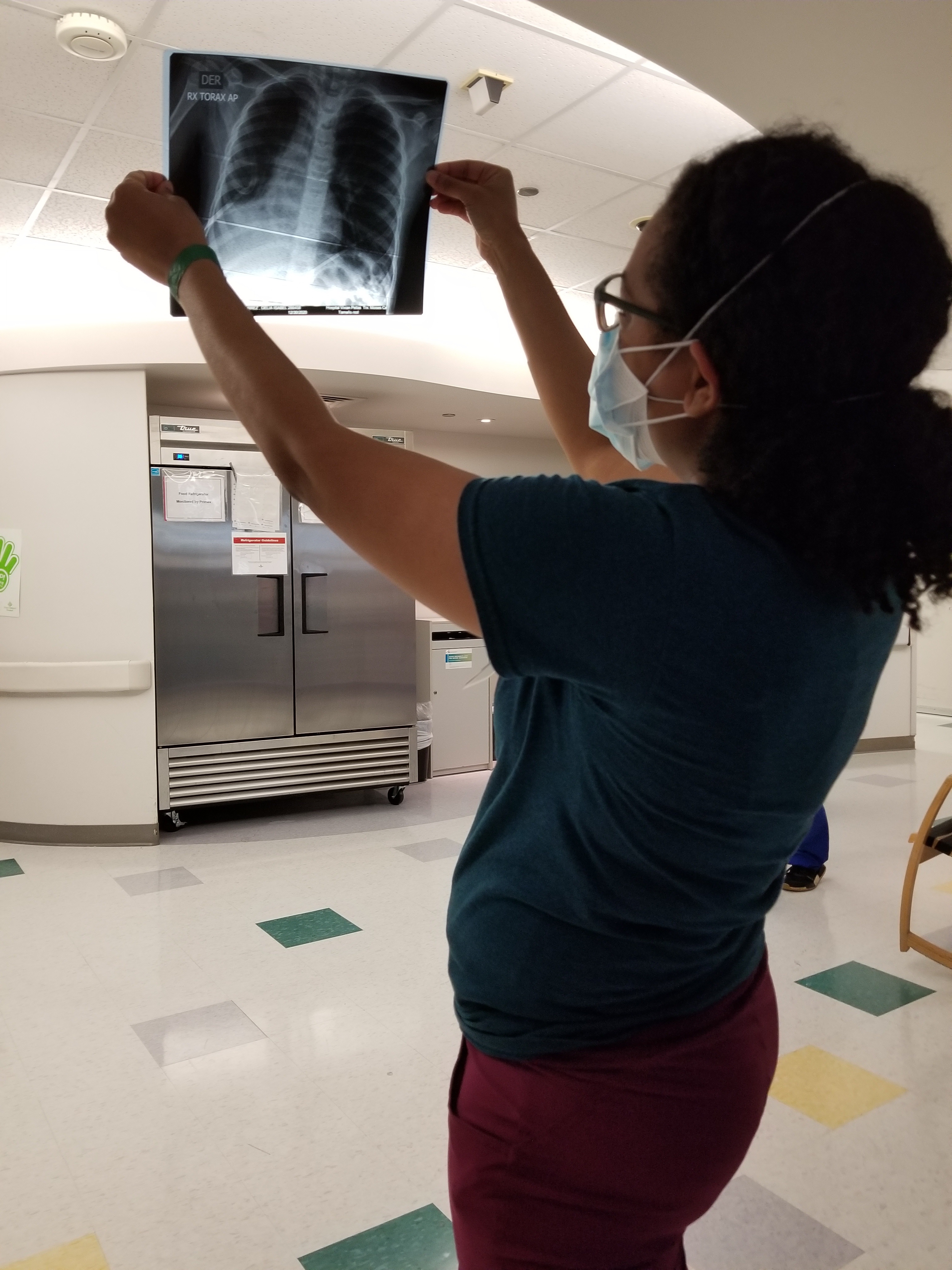 Pediatric Rehabilitation Fellow Jensine’ J. Norman, MD, examining a printed MRI image.